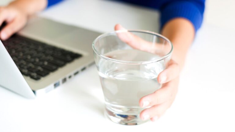 Wie viel Wasser trinken ist gesund - Laptop und Glas