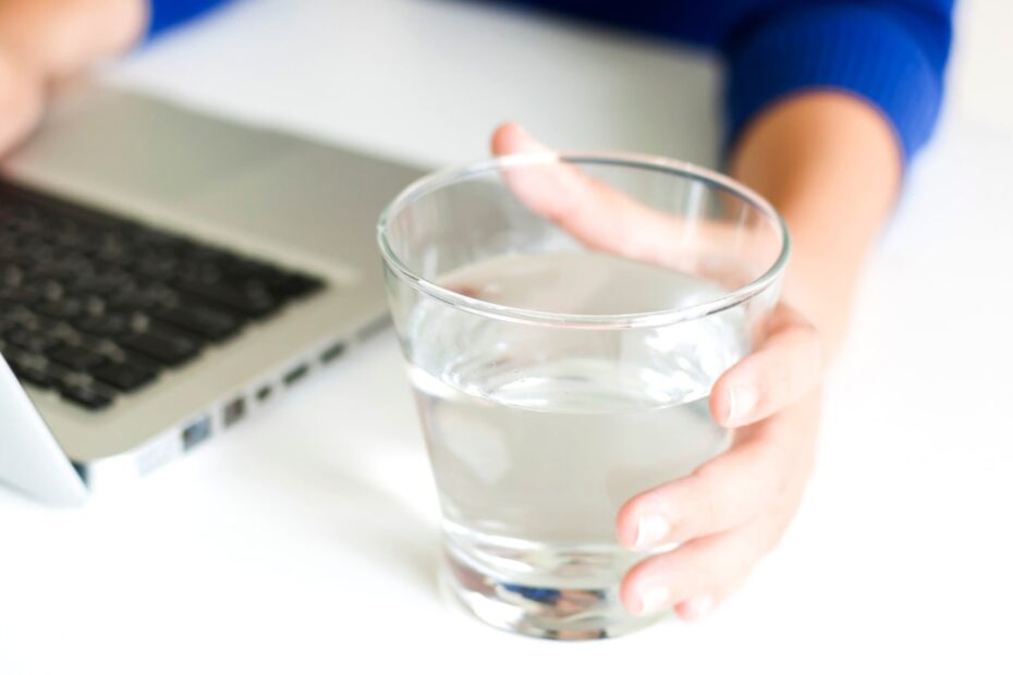 Wie viel Wasser trinken ist gesund - Laptop und Glas